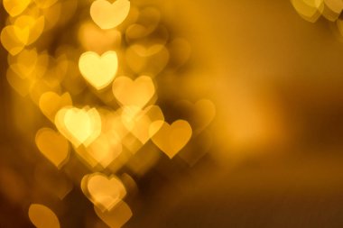 Karanlık bir arka planda, odağındaki kalp şeklinde bir sürü altın ışık. Sevgililer Günü 'nü kutluyoruz