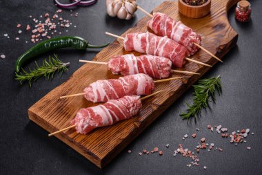 Lezzetli bir parça domuz pastırması ile sarılmış lezzetli bir parça kıyma. Chevapchichi hazırlığı