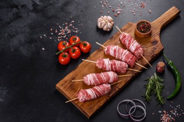 Lezzetli bir parça domuz pastırması ile sarılmış lezzetli bir parça kıyma. Chevapchichi hazırlığı