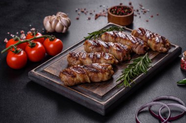 Lezzetli bir parça domuz pastırması ile sarılmış lezzetli bir parça kıyma. Chevapchichi hazırlığı