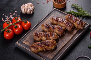 Lezzetli bir parça domuz pastırması ile sarılmış lezzetli bir parça kıyma. Chevapchichi hazırlığı