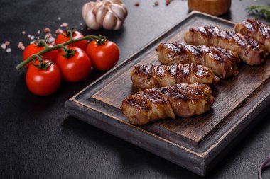 Lezzetli bir parça domuz pastırması ile sarılmış lezzetli bir parça kıyma. Chevapchichi hazırlığı