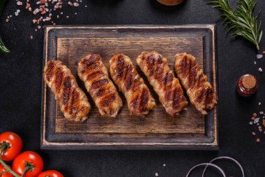 Lezzetli bir parça domuz pastırması ile sarılmış lezzetli bir parça kıyma. Chevapchichi hazırlığı