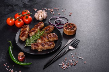 Lezzetli bir parça domuz pastırması ile sarılmış lezzetli bir parça kıyma. Chevapchichi hazırlığı