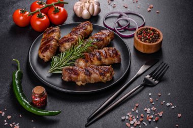 Lezzetli bir parça domuz pastırması ile sarılmış lezzetli bir parça kıyma. Chevapchichi hazırlığı