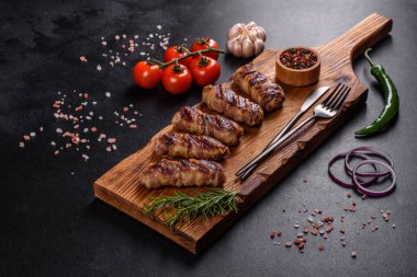 Lezzetli bir parça domuz pastırması ile sarılmış lezzetli bir parça kıyma. Chevapchichi hazırlığı