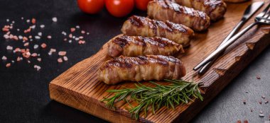 Lezzetli bir parça domuz pastırması ile sarılmış lezzetli bir parça kıyma. Chevapchichi hazırlığı