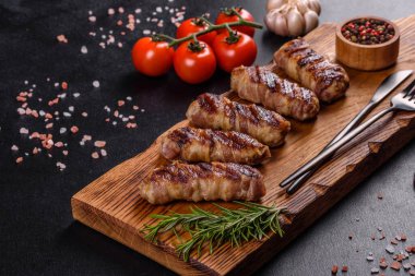 Lezzetli bir parça domuz pastırması ile sarılmış lezzetli bir parça kıyma. Chevapchichi hazırlığı