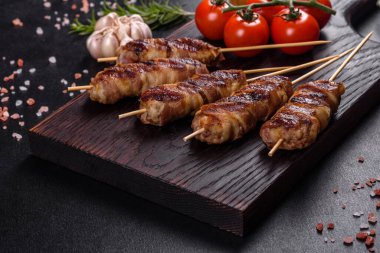 Lezzetli bir parça domuz pastırması ile sarılmış lezzetli bir parça kıyma. Chevapchichi hazırlığı