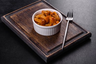 Canned mushrooms in a bowl on a dark background