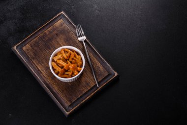 Canned mushrooms in a bowl on a dark background