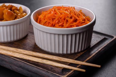 Vegetable appetizer Korean carrots with garlic and pepper and parsley in a bowl on a dark background