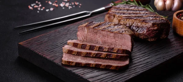 暗い背景に新鮮なジューシーなおいしい牛肉ステーキ スパイスとハーブの肉料理 — ストック写真