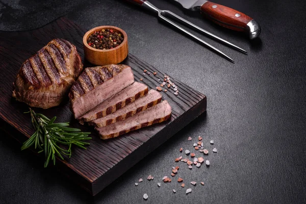 暗い背景に新鮮なジューシーなおいしい牛肉ステーキ スパイスとハーブの肉料理 — ストック写真