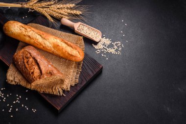 Siyah arkaplanda taze ekmek, üst görünüm, kopyalama alanı. Ev yapımı taze fırınlanmış çeşitli somunlar ve çavdar ekmeği.