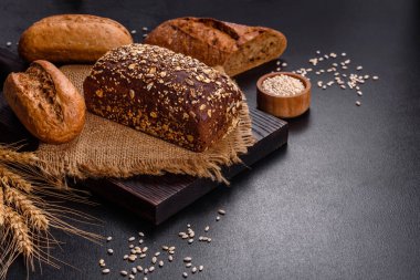 Siyah arkaplanda taze ekmek, üst görünüm, kopyalama alanı. Ev yapımı taze fırınlanmış çeşitli somunlar ve çavdar ekmeği.