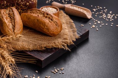 Siyah arkaplanda taze ekmek, üst görünüm, kopyalama alanı. Ev yapımı taze fırınlanmış çeşitli somunlar ve çavdar ekmeği.