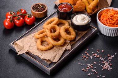 Lezzetli altın hırpalanmış, ekmekli ve ketçaplı kızarmış soğan halkaları.