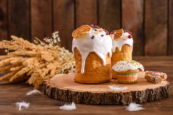 Festive cakes with white glaze, nuts and raisins on the festive table. Preparations for Easter