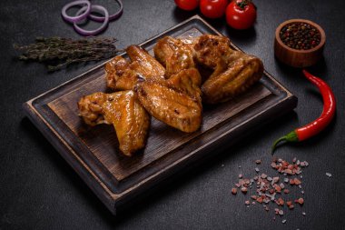 Siyah arka planda sebze ve baharatlı kızarmış tavuk kanadı.