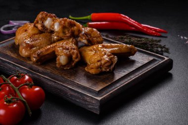 Siyah arka planda sebze ve baharatlı kızarmış tavuk kanadı.