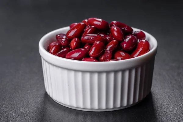 Tasty canned red beans in a beautiful white bowl on a wooden board