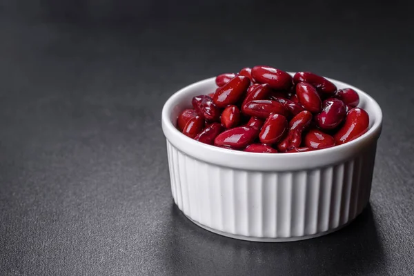 Tasty canned red beans in a beautiful white bowl on a wooden board