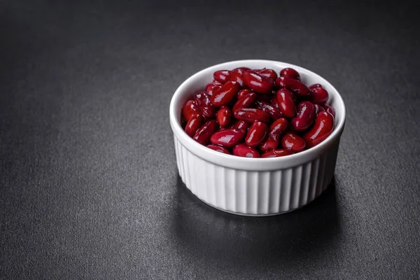 Tasty canned red beans in a beautiful white bowl on a wooden board