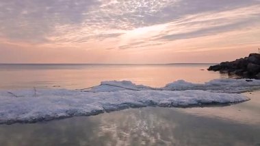 Akşamları, renkli bulutlarla denizin üzerinde gün batımı.