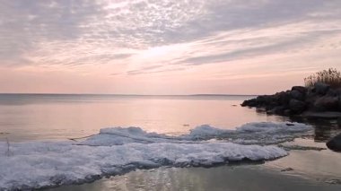 Akşamları, renkli bulutlarla denizin üzerinde gün batımı.