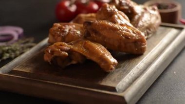 Siyah arka planda sebze ve baharatlı fırında tavuk kanadı.