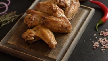 Siyah arka planda sebze ve baharatlı fırında tavuk kanadı.