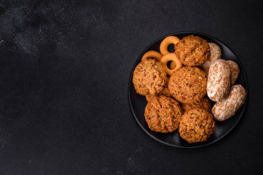 Koyu beton arka planda lezzetli taze yulaf kurabiyeleri. Lezzetli, sağlıklı tatlılar.