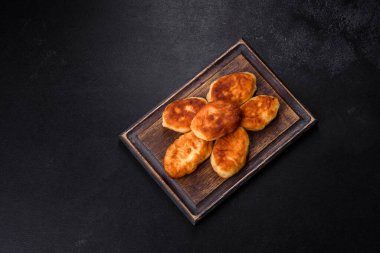 Koyu beton arka planda patatesli lezzetli ev yapımı turtalar. Ev yapımı hamur işleri.