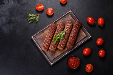 Siyah beton arka planda sebzeli şiş kebap.