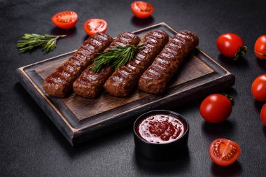 Siyah beton arka planda sebzeli şiş kebap.