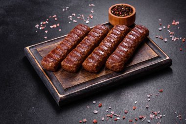 Siyah beton arka planda sebzeli şiş kebap.