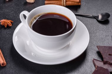 Siyah zemin üzerinde yıldız anason ve tarçın olan kırık siyah çikolata parçaları.