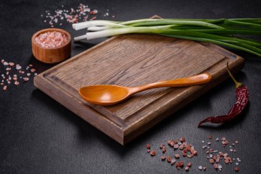 Kesme tahtasındaki soğan soğanlarını kes. Koyu tahta arkaplan