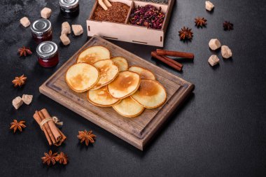 Tahta kesme tahtasının üzerinde nefis taze krepler ve koyu beton arka planda şeker.