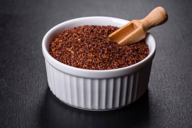 Siyah arka planda beyaz kâse içinde Rooibos çayı. Düz konum, üst görünüm, kopyalama alanı
