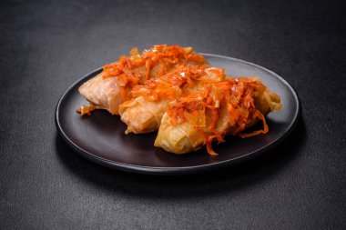 Geleneksel doldurulmuş lahana, kıyma ve pilav, domates sosunda servis edilir.