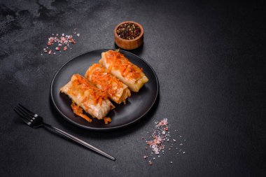 Geleneksel doldurulmuş lahana, kıyma ve pilav, domates sosunda servis edilir.