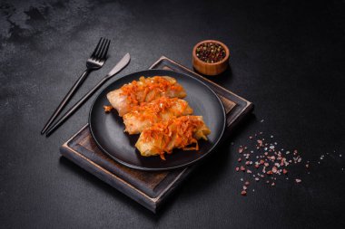 Geleneksel doldurulmuş lahana, kıyma ve pilav, domates sosunda servis edilir.