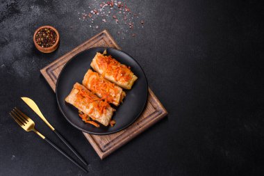 Geleneksel doldurulmuş lahana, kıyma ve pilav, domates sosunda servis edilir.