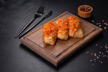 Geleneksel doldurulmuş lahana, kıyma ve pilav, domates sosunda servis edilir.