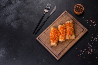 Geleneksel doldurulmuş lahana, kıyma ve pilav, domates sosunda servis edilir.