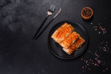 Geleneksel doldurulmuş lahana, kıyma ve pilav, domates sosunda servis edilir.