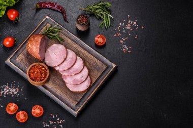 Lezzetli taze jambon. Koyu beton arka planda tahta kesme tahtasının üzerinde dilimler var.