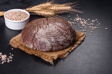 Esmer taze ekmek ve koyu beton arka planda tohumlar. Üst görünüm, alanı kopyala